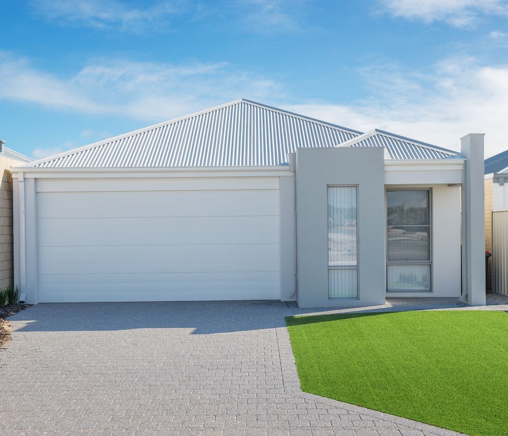 A modern, single-story residential house with a white garage, gray accent wall, and a gray metal roof under a blue sky — GV painting in Shepparton, VIC