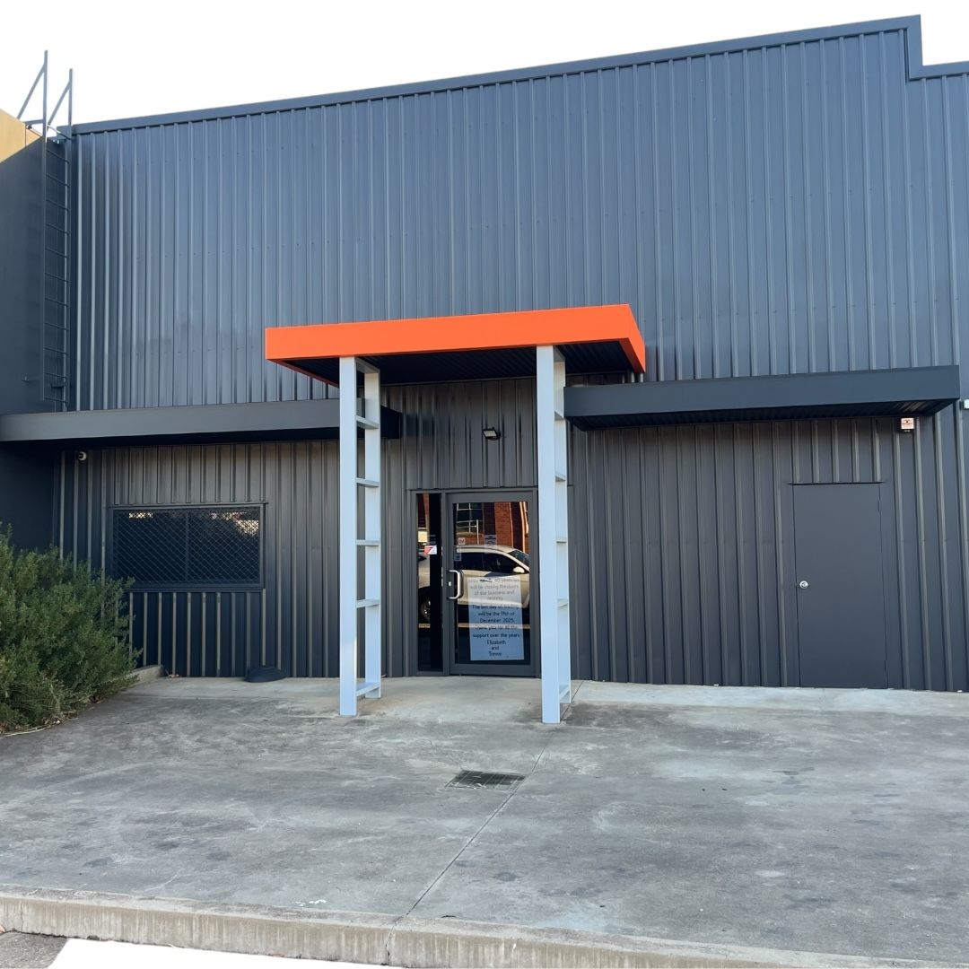 Dark Gray Industrial Building With Orange Awning Over a Doorway — GV painting in Shepparton, VIC