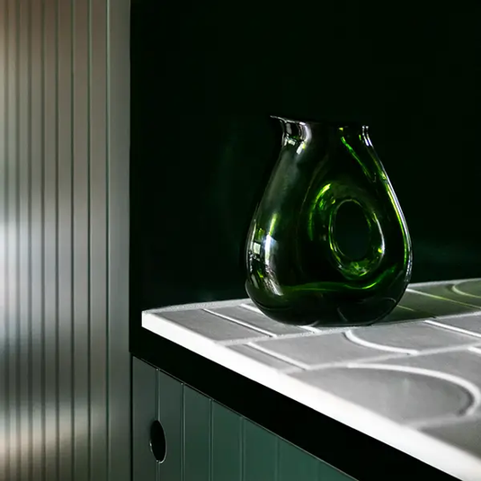 Green Glass Vase on a White Tiled Surface Against a Dark Green Backdrop — GV painting in Shepparton, VIC