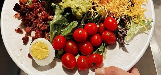 A plate of food with eggs benedict and potatoes on it