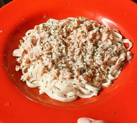 A white plate topped with a piece of meat and rice