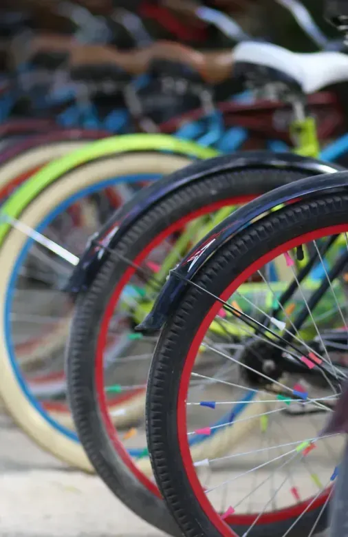 A row of bicycles are parked next to each other on a sidewalk.