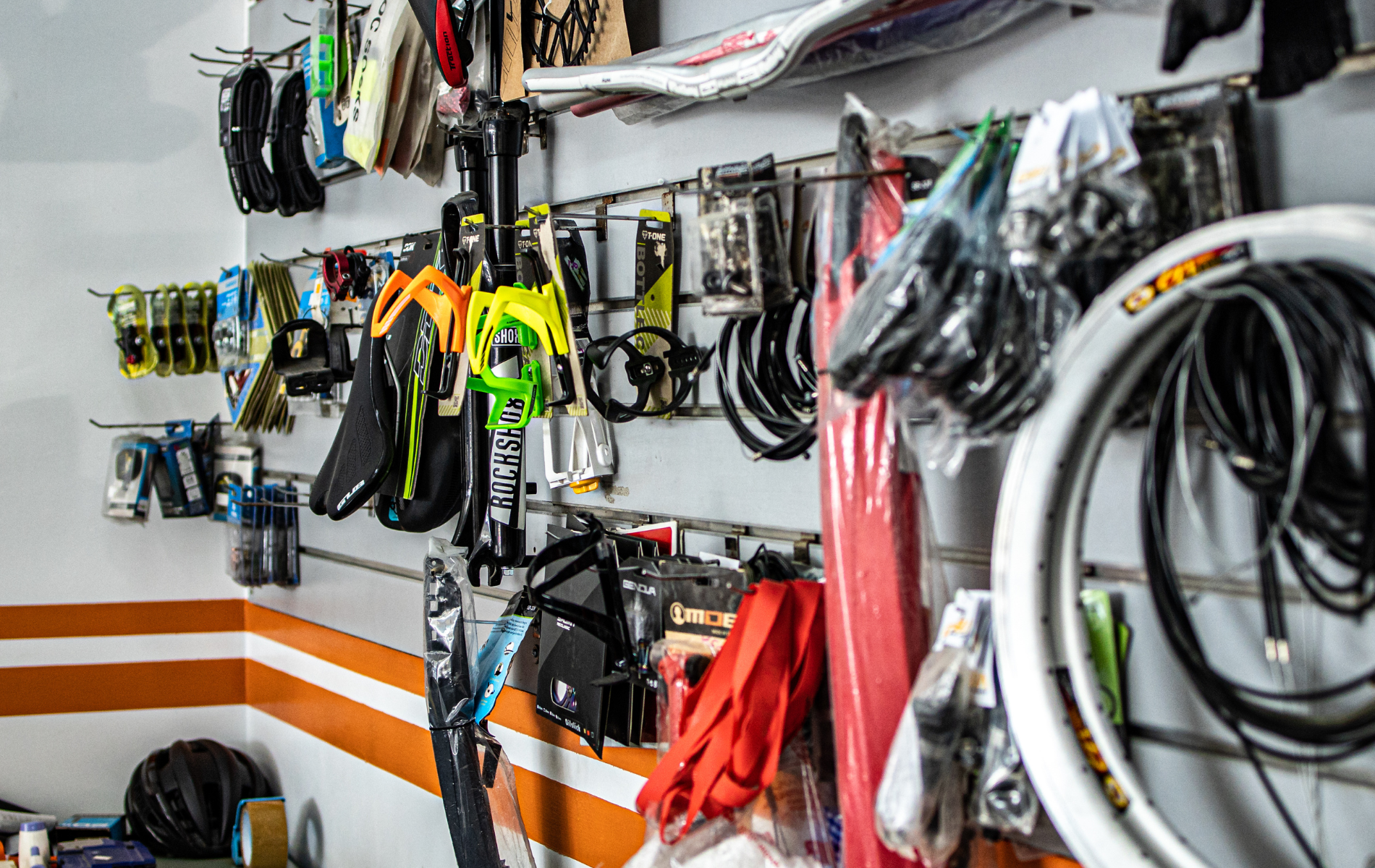 A bunch of bicycle parts are hanging on a wall in a store.