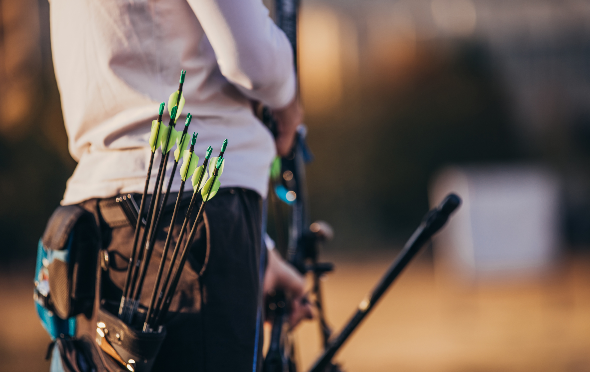 A man is holding a bow and arrows in his pocket.