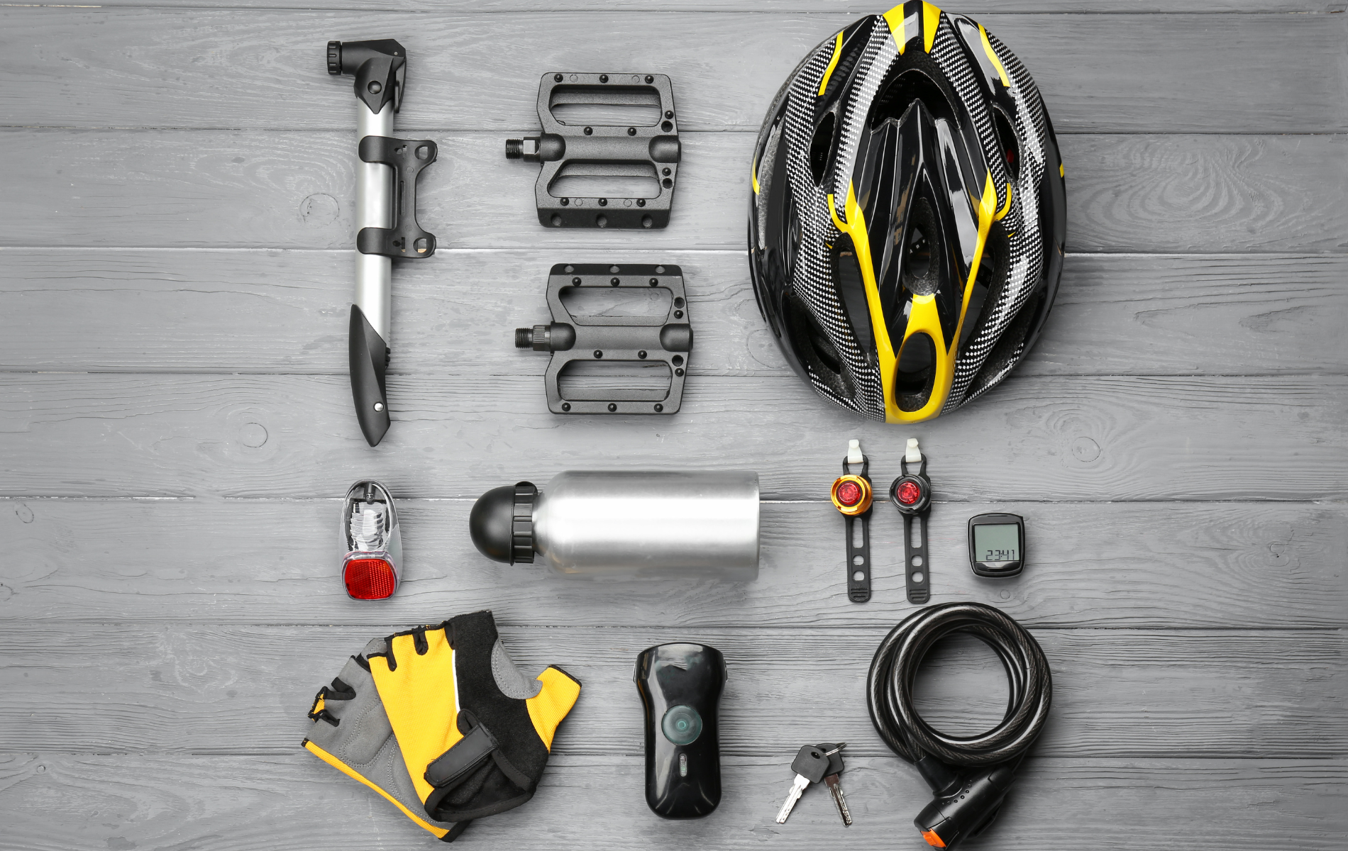 A variety of bicycle accessories are laid out on a wooden table.