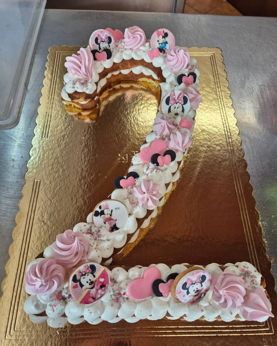 Tavolo per la festa di compleanno con torta, ciambelle, cappellini da festa e tazze.