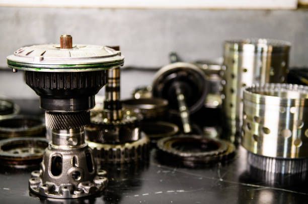 Auto transmission rebuild showing detailed view of disassembled automatic gearshift parts on table.