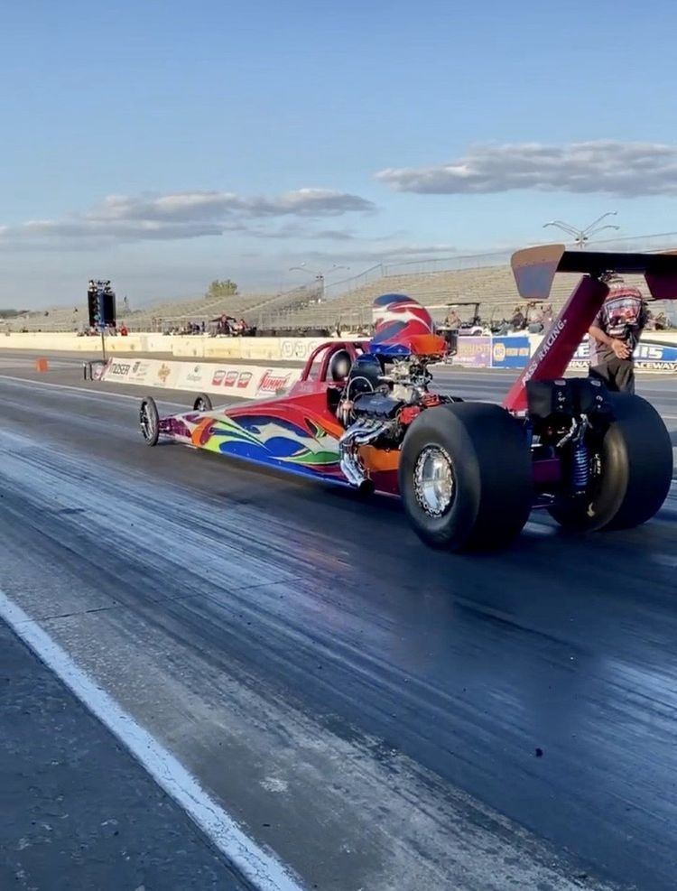 A Red and Blue Dragster is Driving Down a Race Track — Smyrna, GA — All Pro Transmission