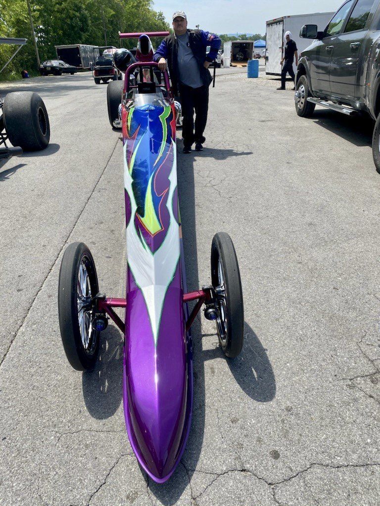 A Man Stands Next to a Purple and White Dragster — Smyrna, GA — All Pro Transmission
