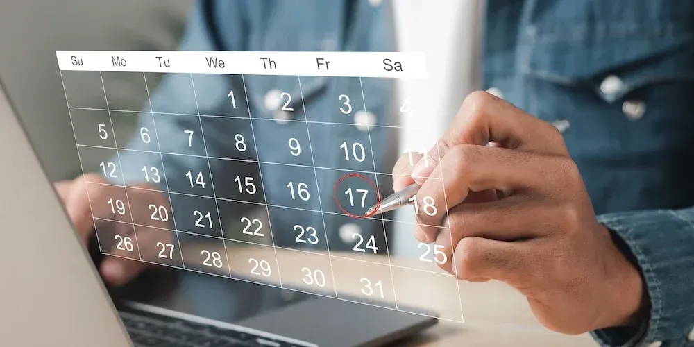 A person is looking at a calendar on a laptop computer.