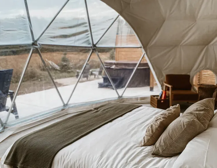 A bedroom in a dome with a bed and chairs.