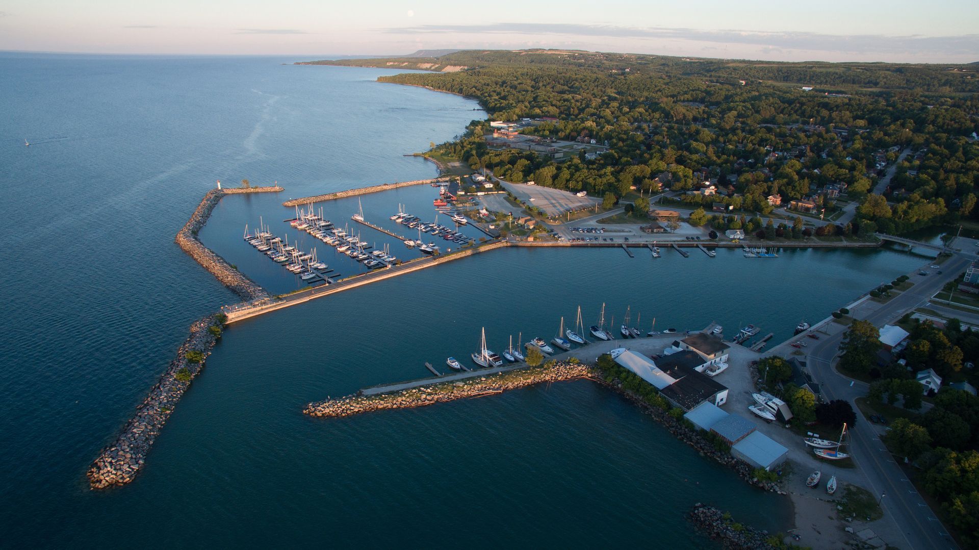 an aerial view of a marina with boats docked in the water .