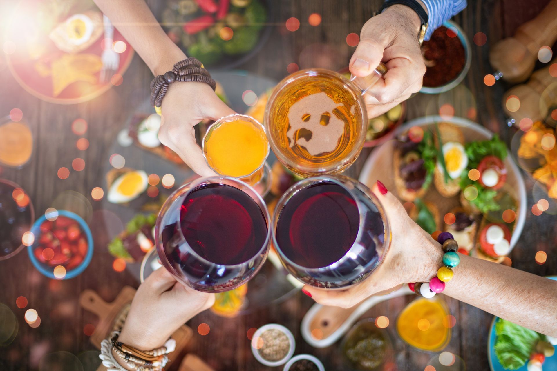A group of people are toasting with wine glasses and beer.