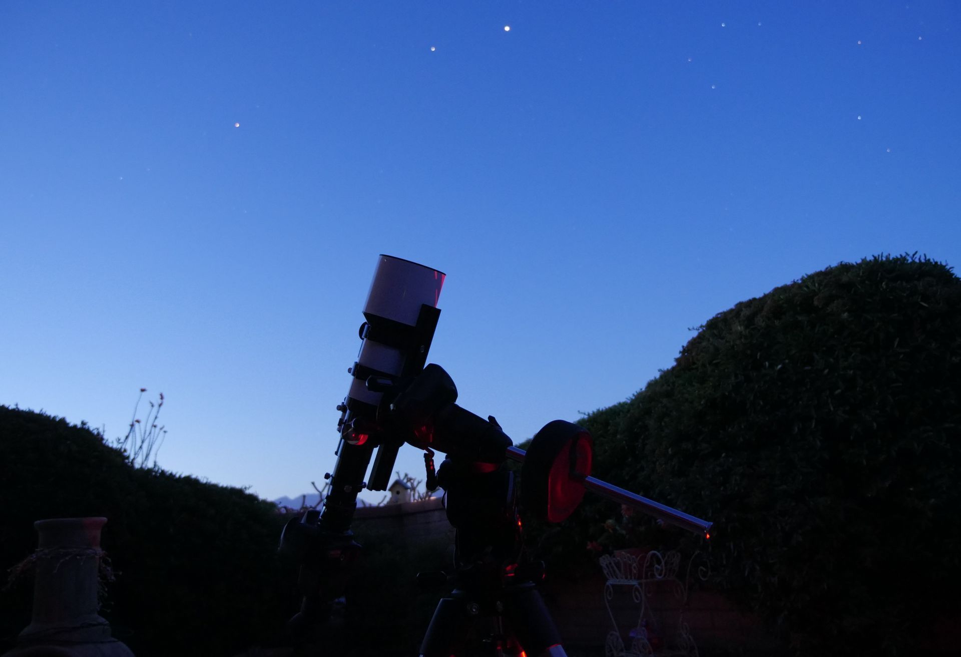 A person is looking through a telescope at the night sky