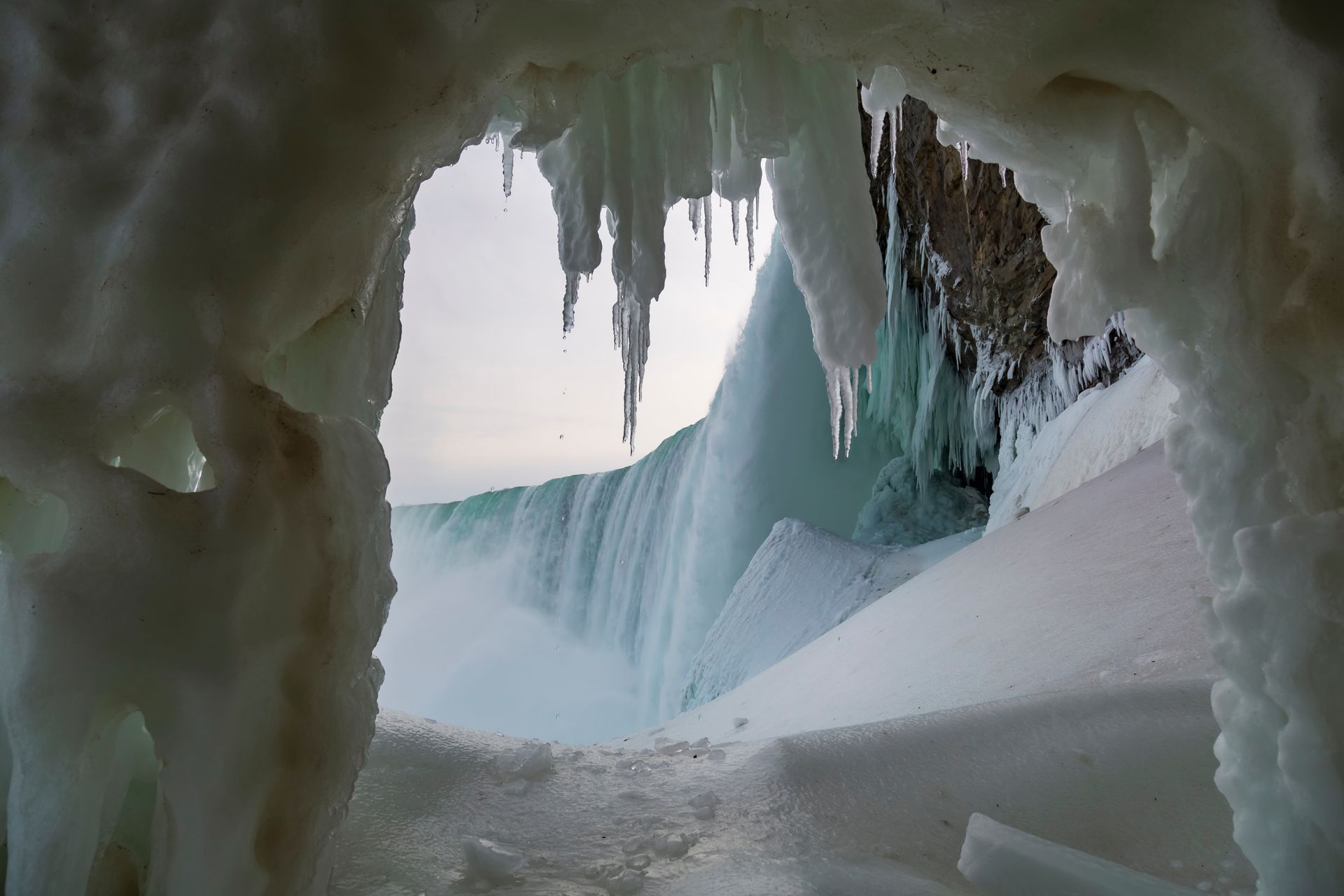 A view of a waterfall through an ice cave.