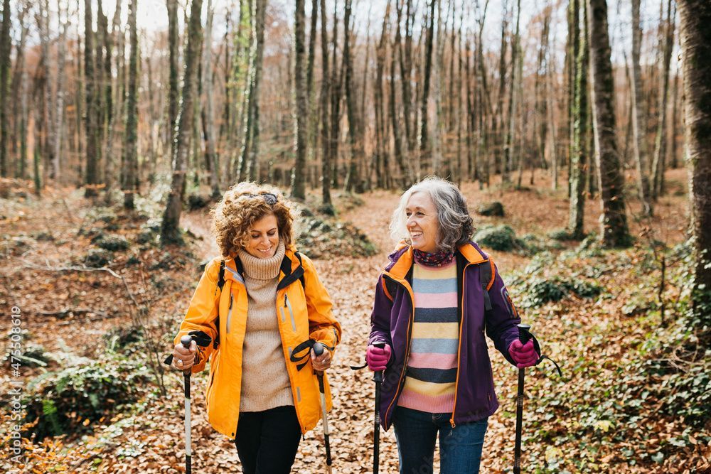 A man and a woman are standing back to back holding hands.