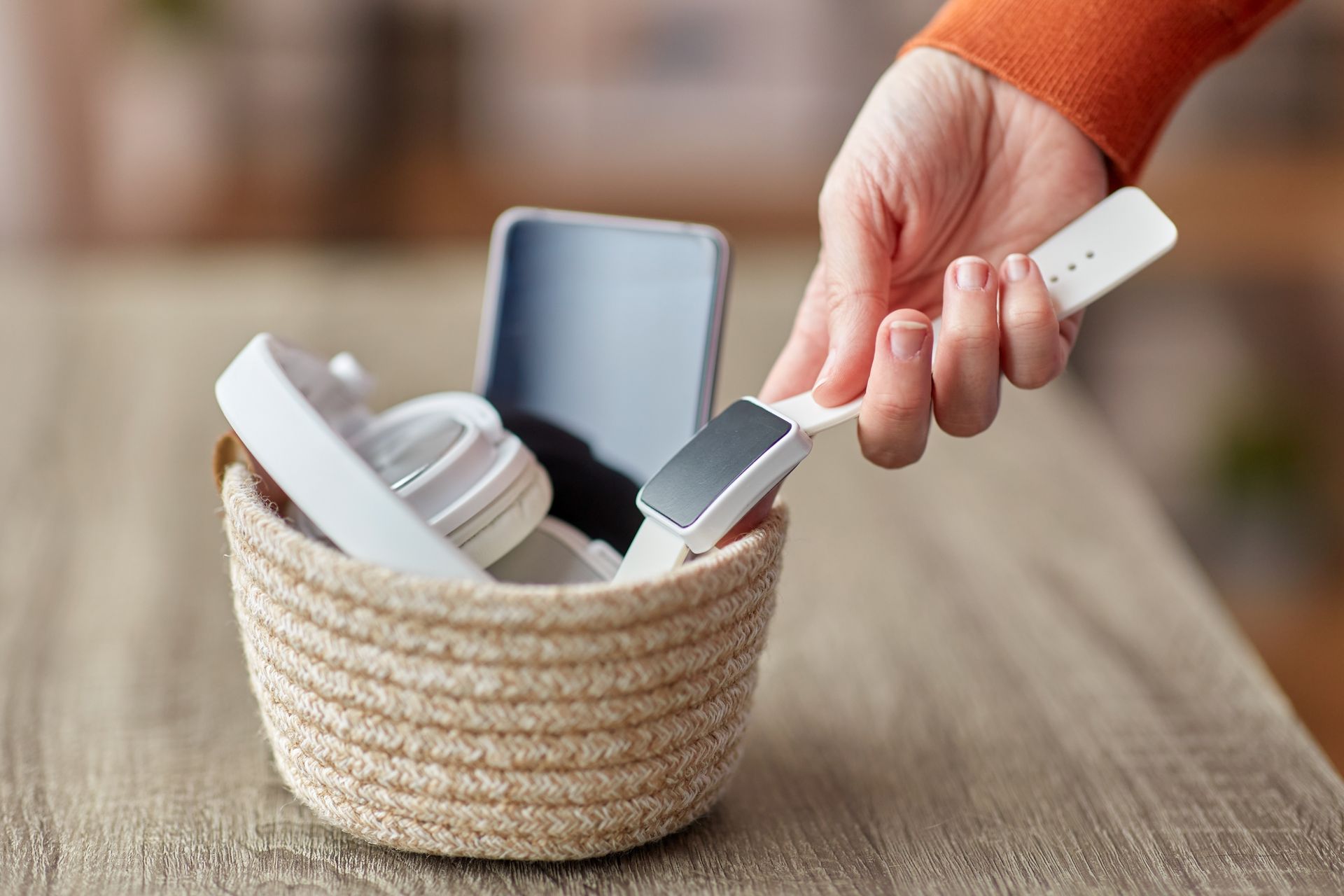 A person is holding a foot file in a basket on a table.