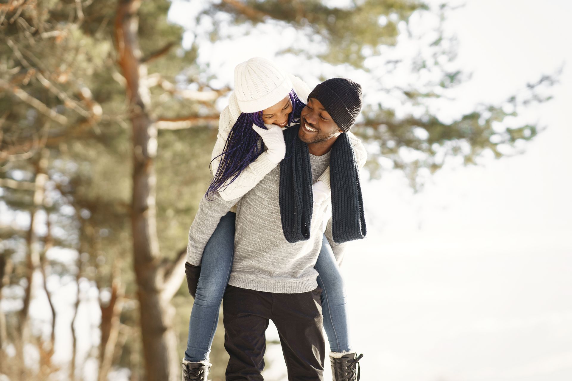 A man is carrying a woman on his shoulders in the snow.