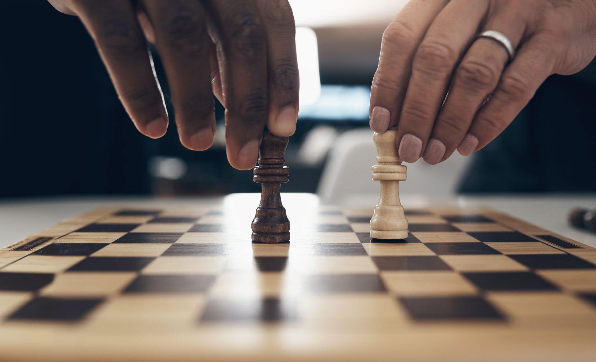 Two people are playing a game of chess on a chess board.