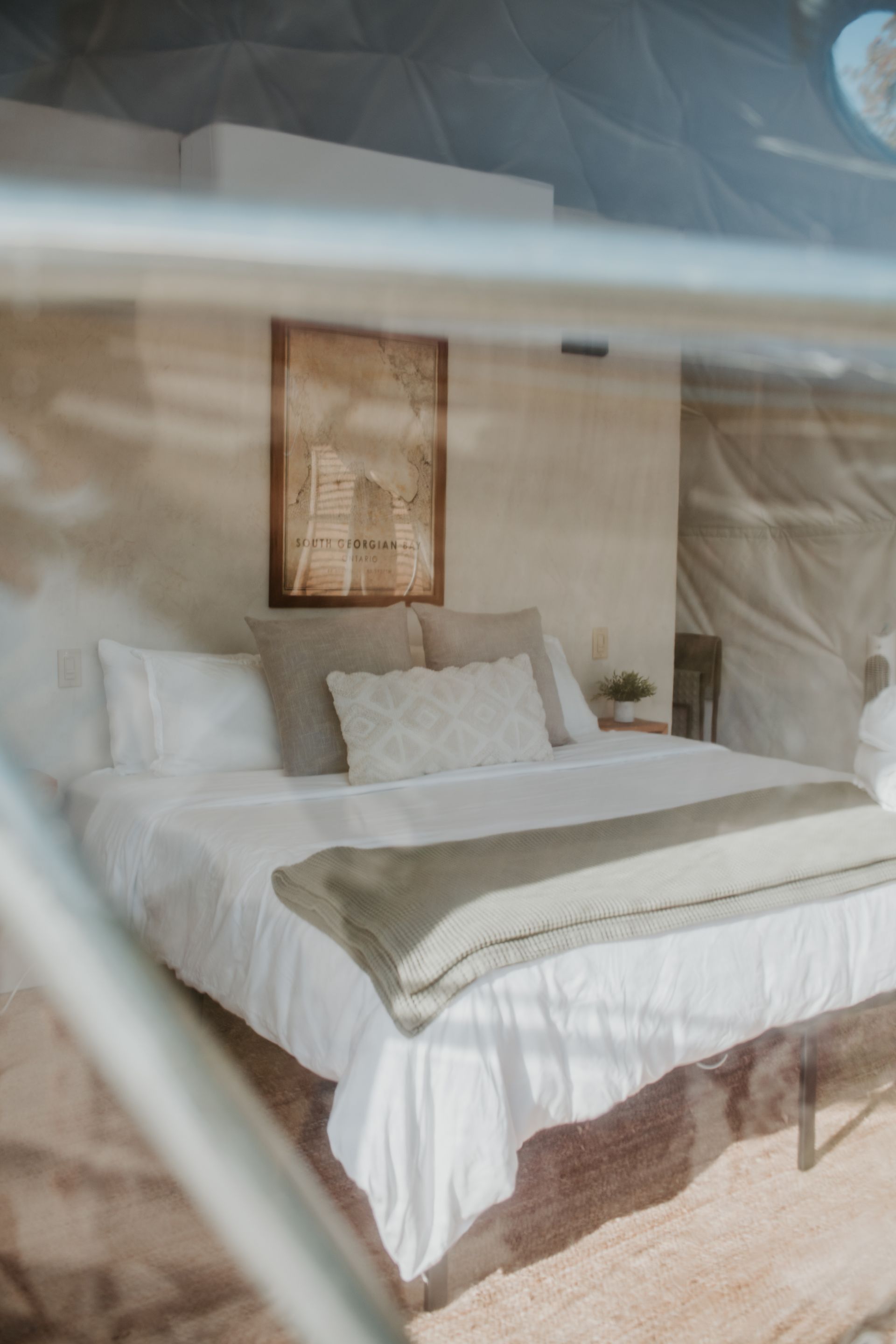A bed with white sheets and pillows is sitting in a bedroom.