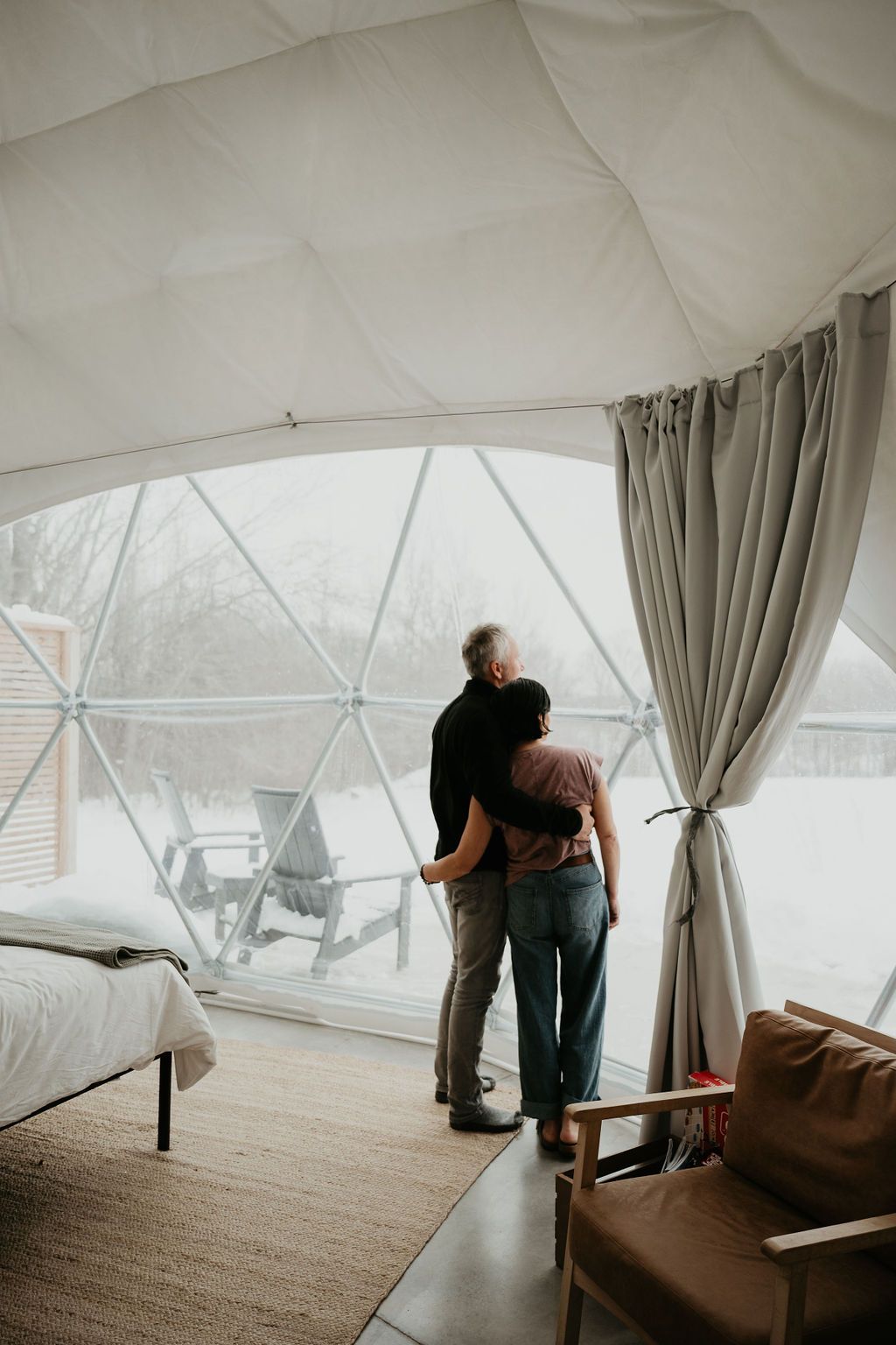 A man and a woman are standing in a dome looking out the window.