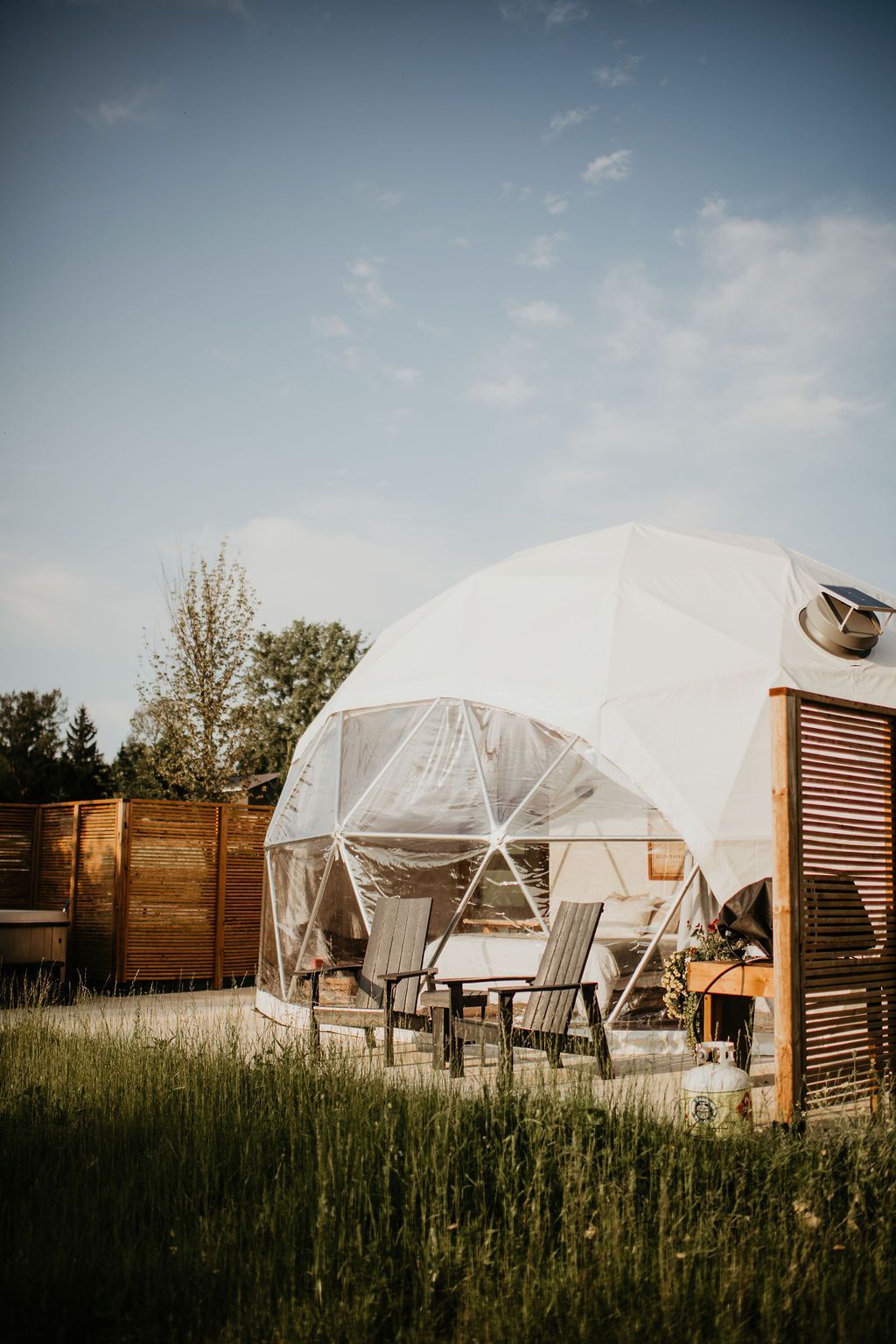 A dome tent is sitting in the middle of a grassy field.