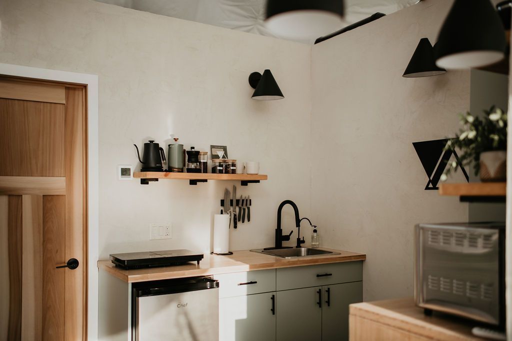 A kitchen with a sink , dishwasher , and microwave.