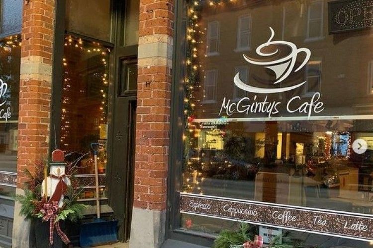 A coffee shop with a cup of coffee on the window.