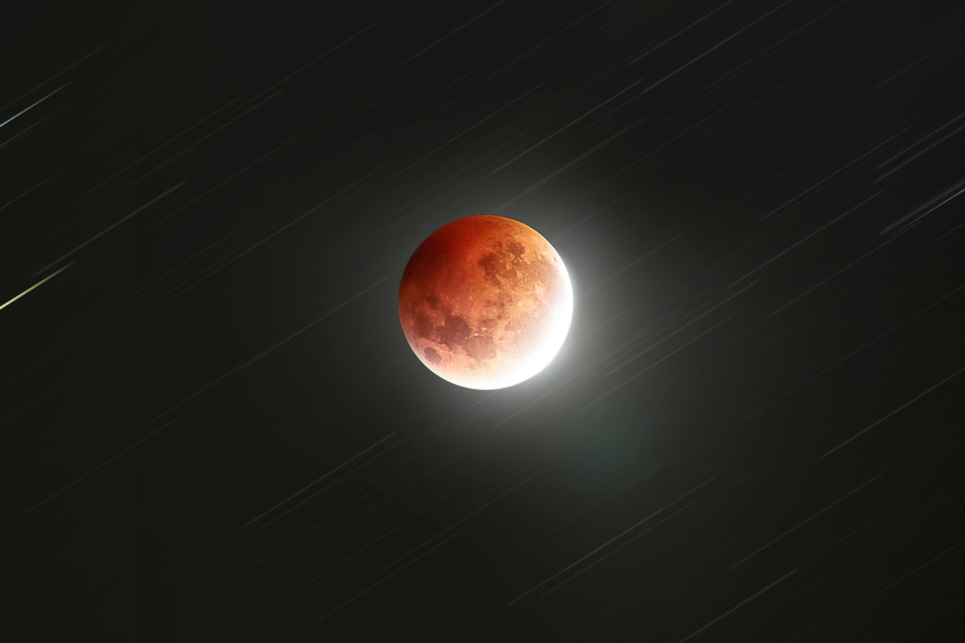 A partial lunar eclipse is visible in the night sky