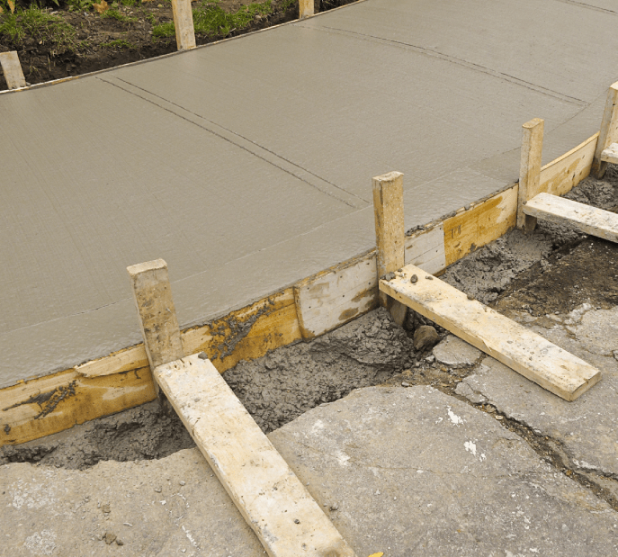 Freshly poured concrete sidewalk with wooden framing and supports.