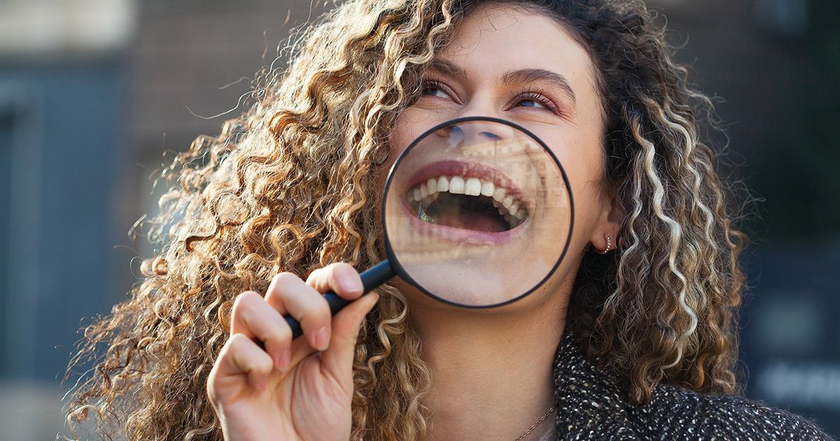 woman laughing holding magnifying glass