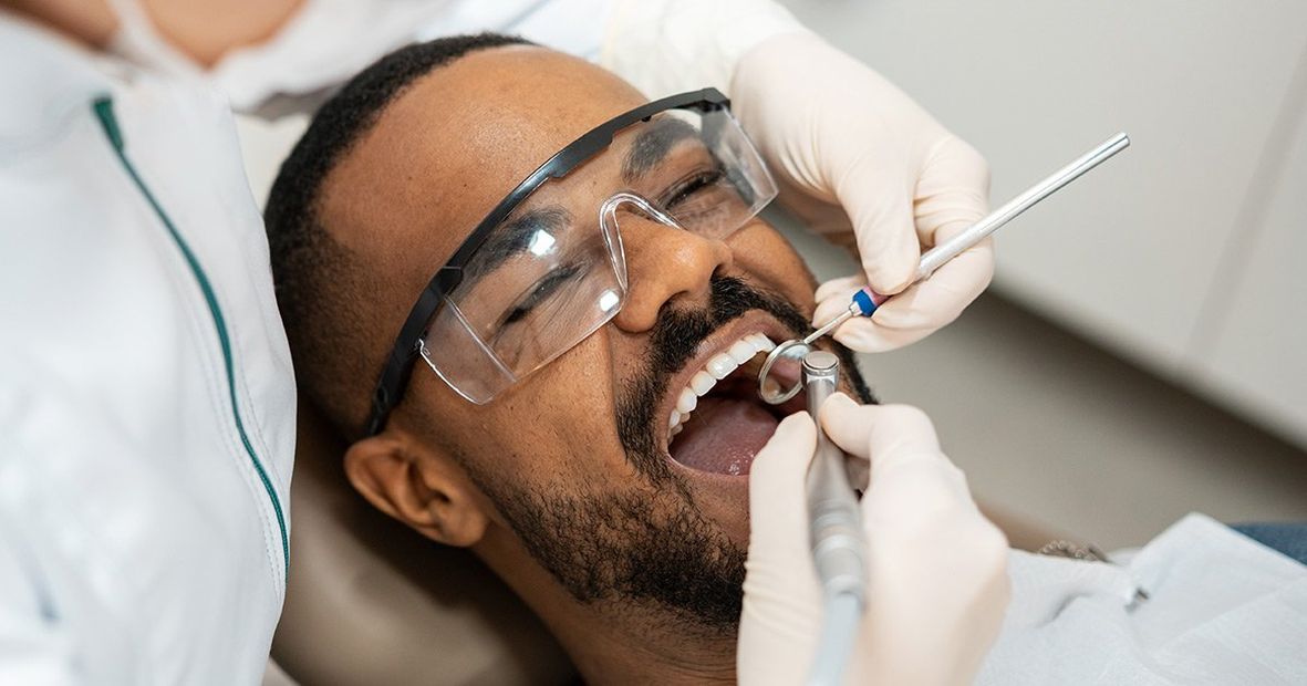 a man is getting his teeth examined by a dentist .