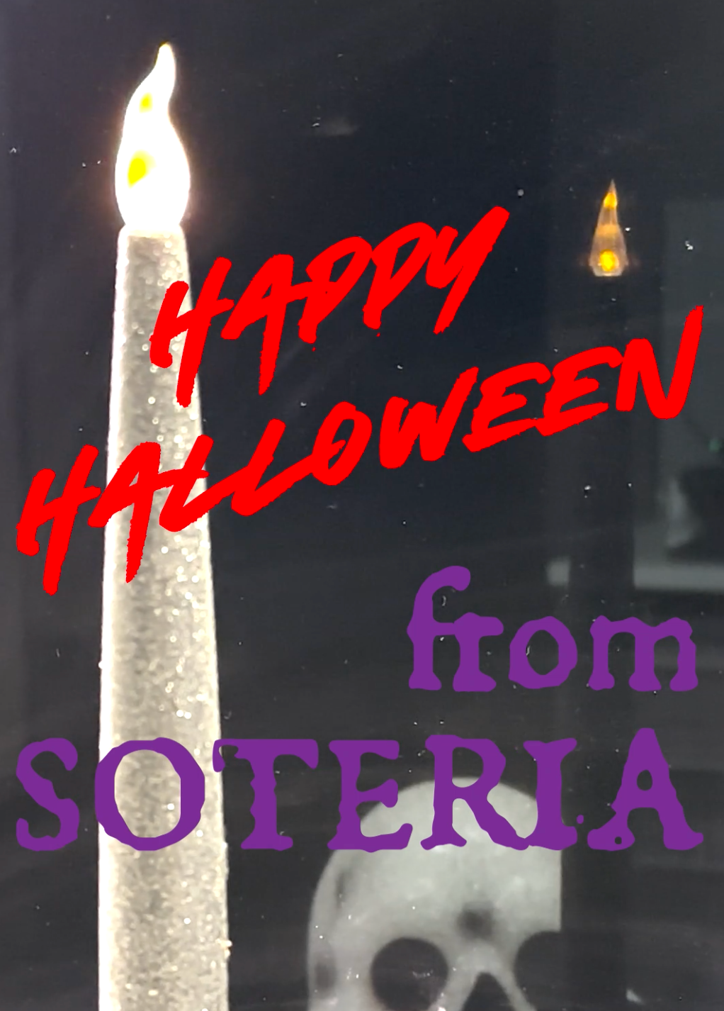 A candle and skull are reflected in a black mirror, text: Happy Halloween from Soteria