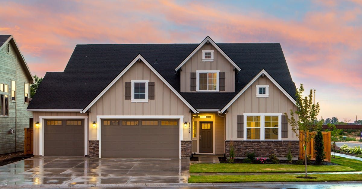 A new two-story home with a soft pink and blue sunset in the background.