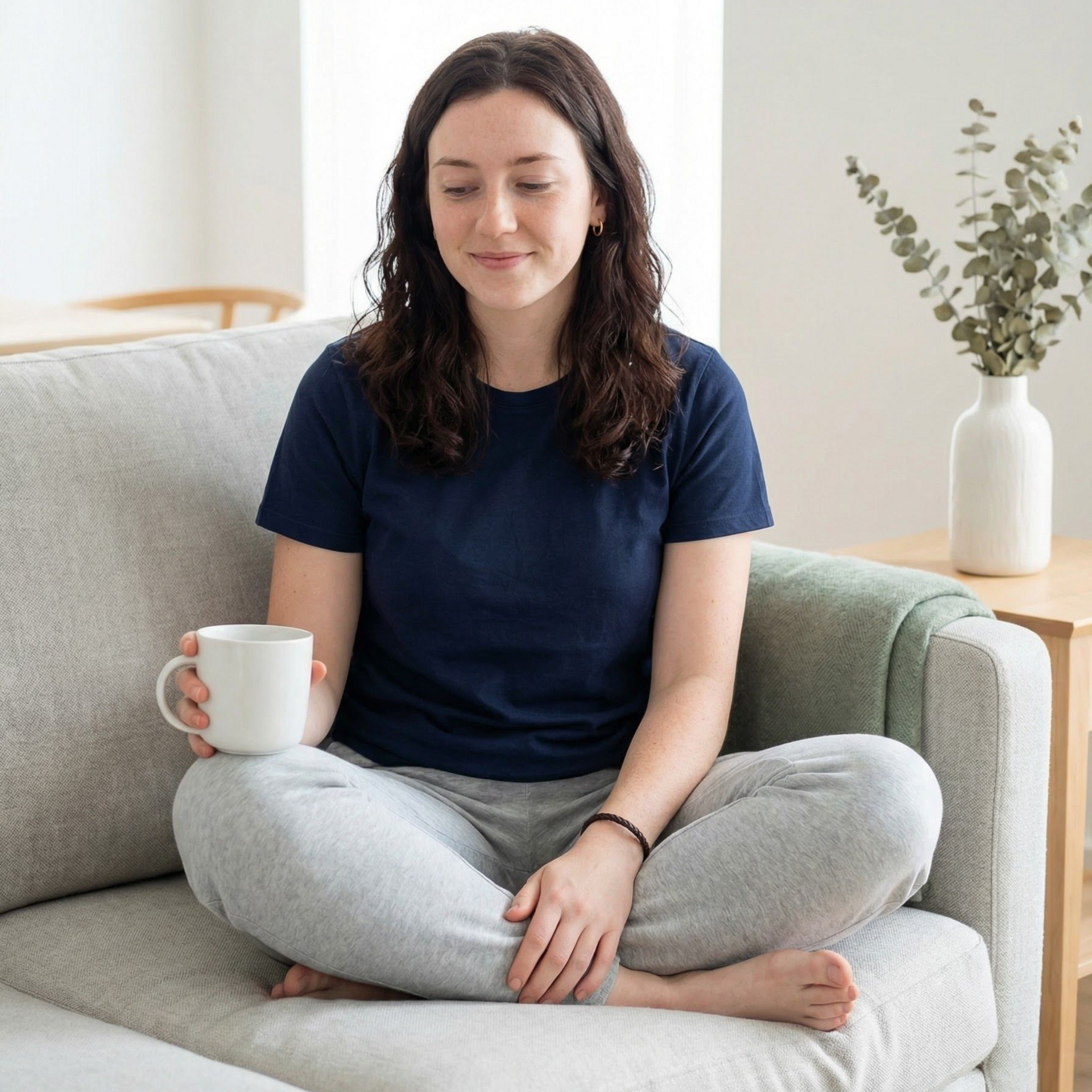 Man looking stressed at laptop, seated at desk near window.