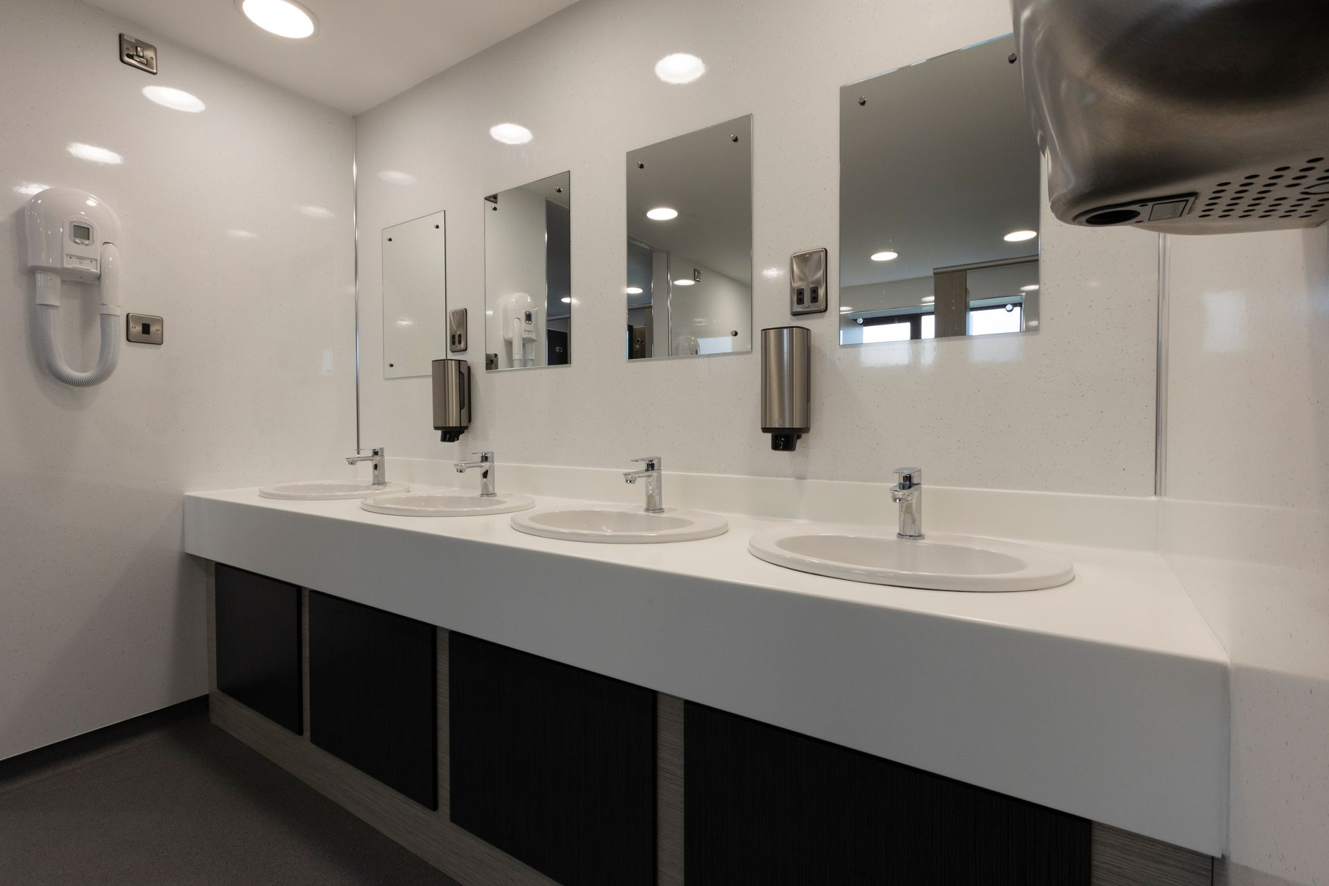 A bathroom with a lot of sinks and mirrors