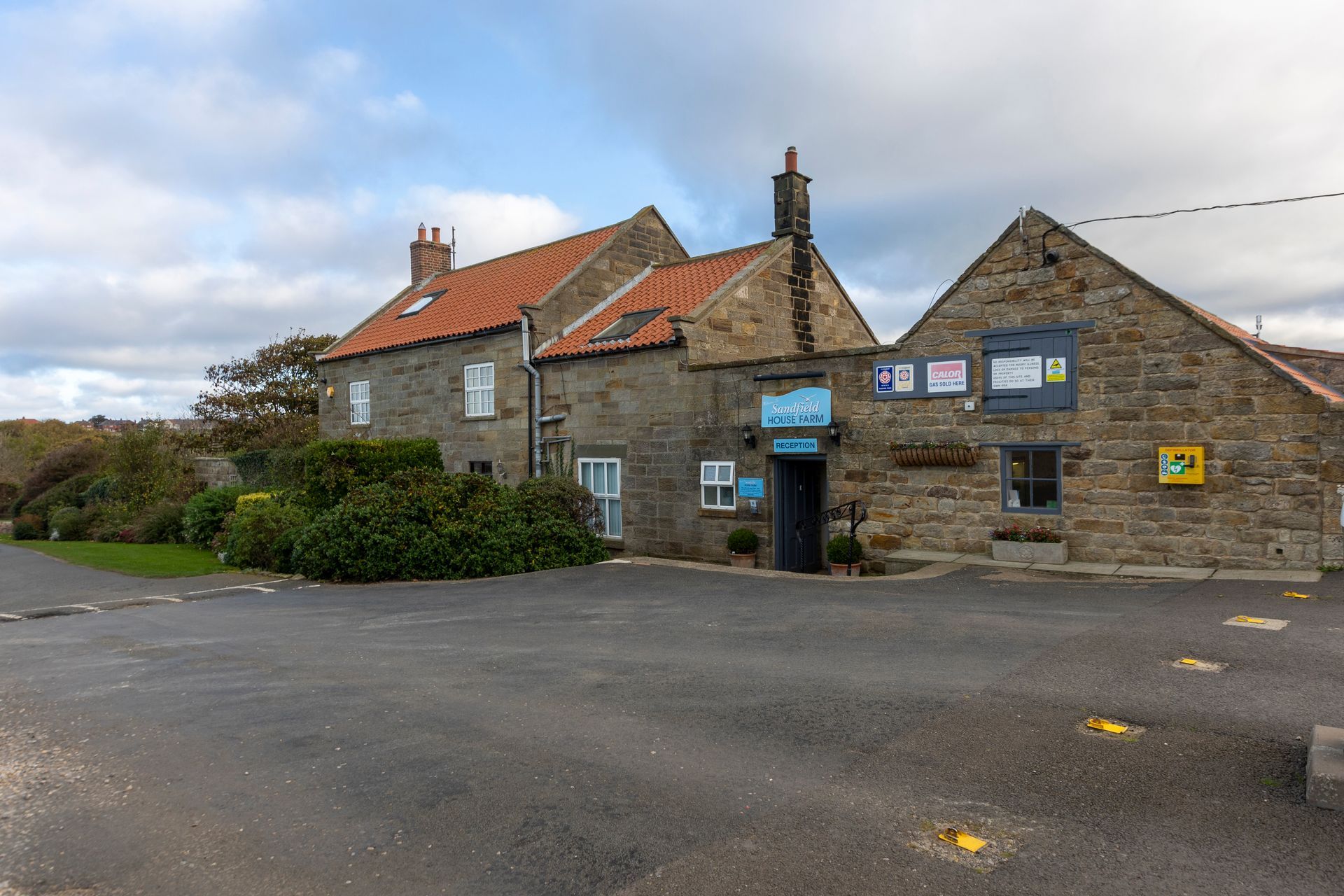 A large stone building with a parking lot in front of it.