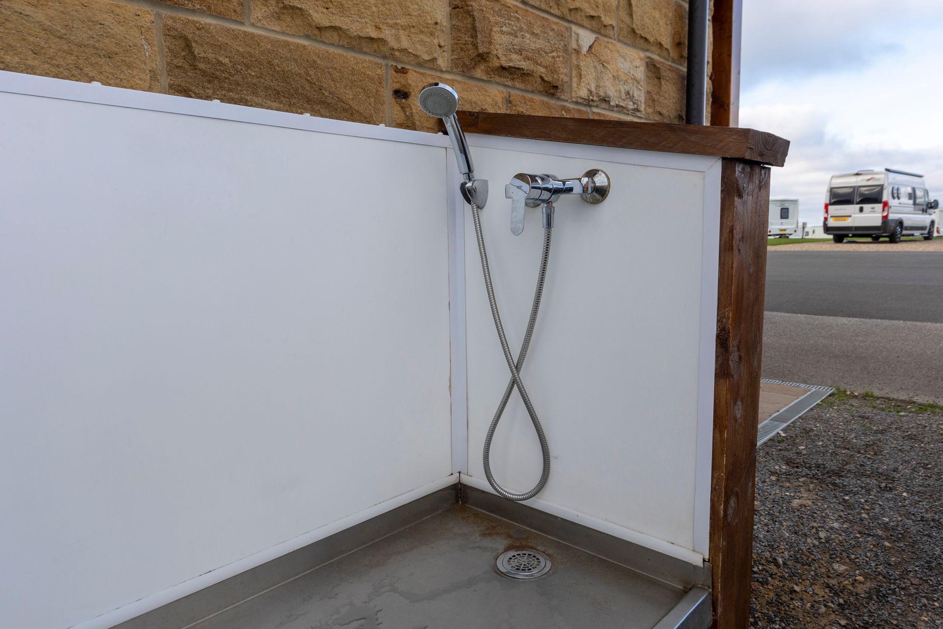 A dog shower stall with a shower head attached to it.