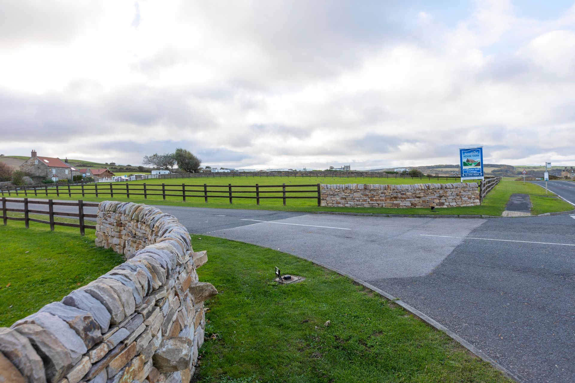 There is a stone wall along the side of the road.
