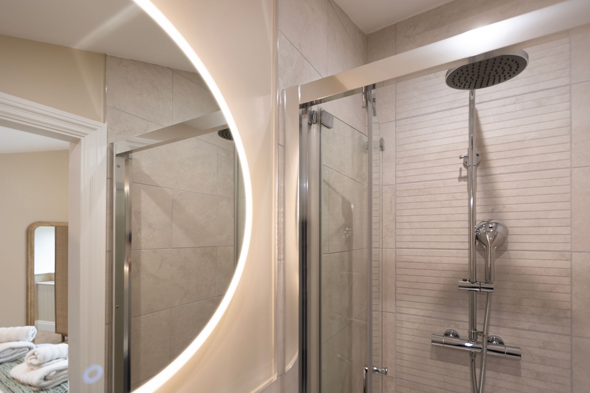 A bathroom with a shower , mirror and shower head.