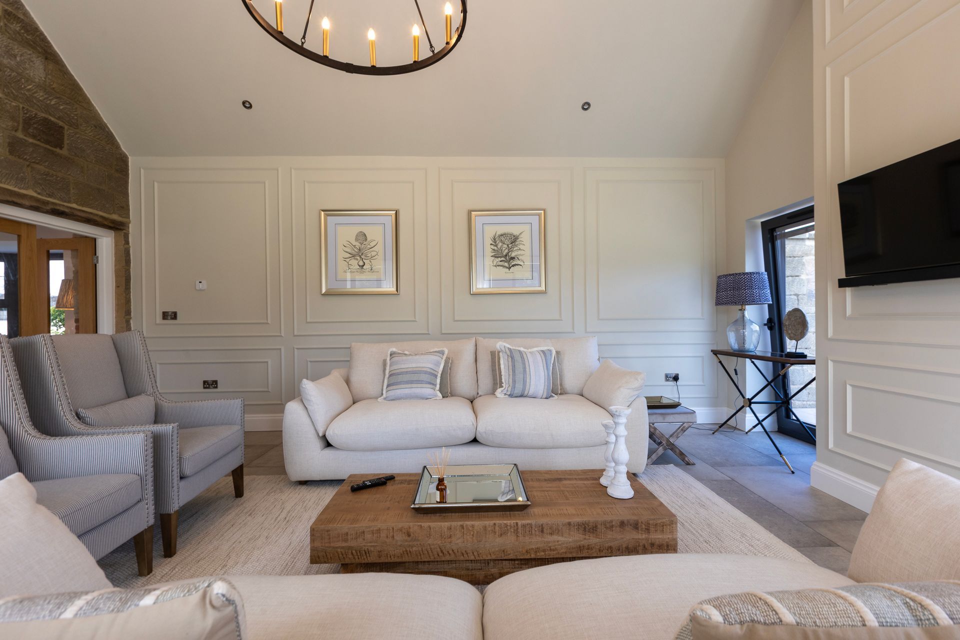 A living room with a couch , chairs , coffee table and television.