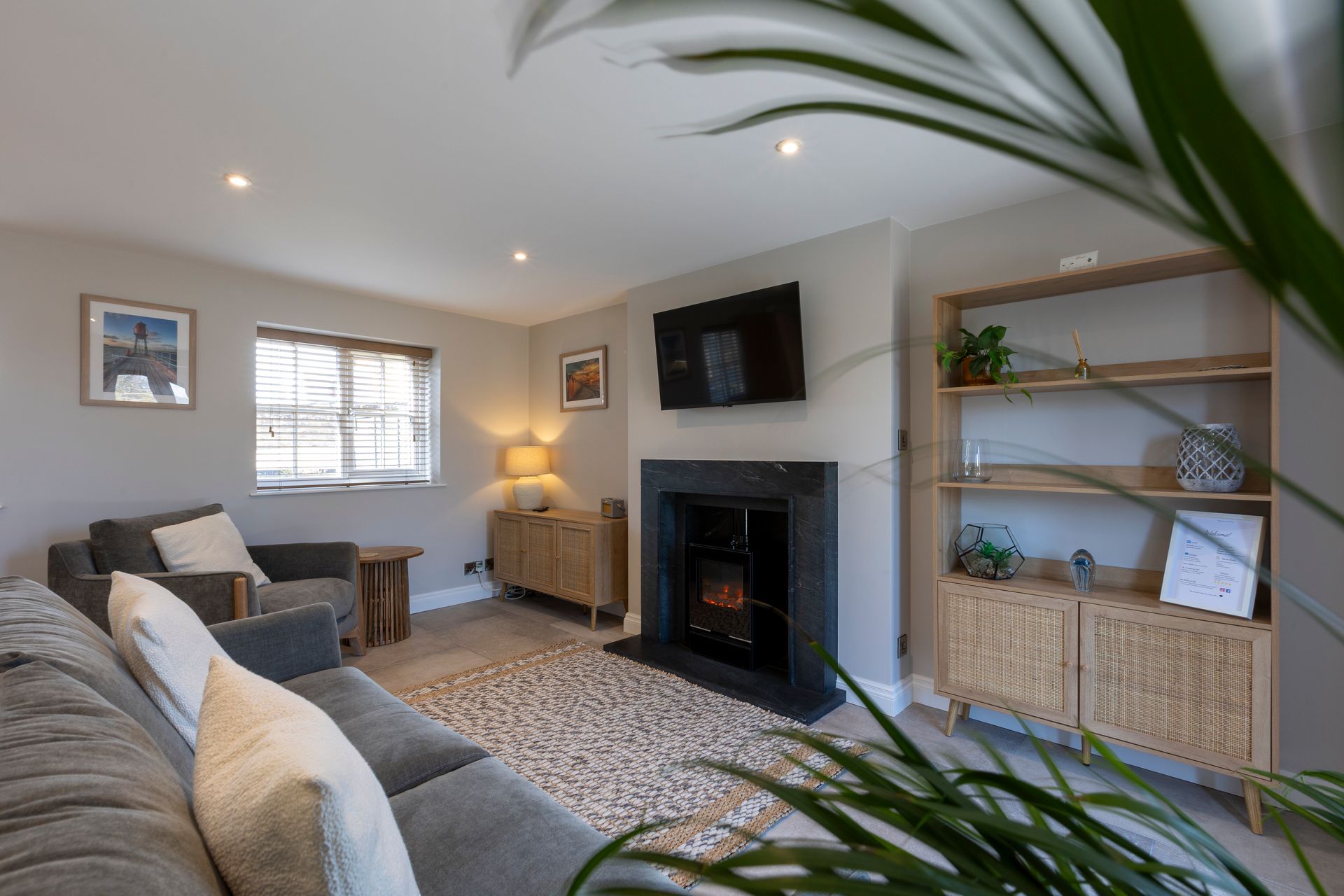 A living room with a couch , chair , fireplace and television.