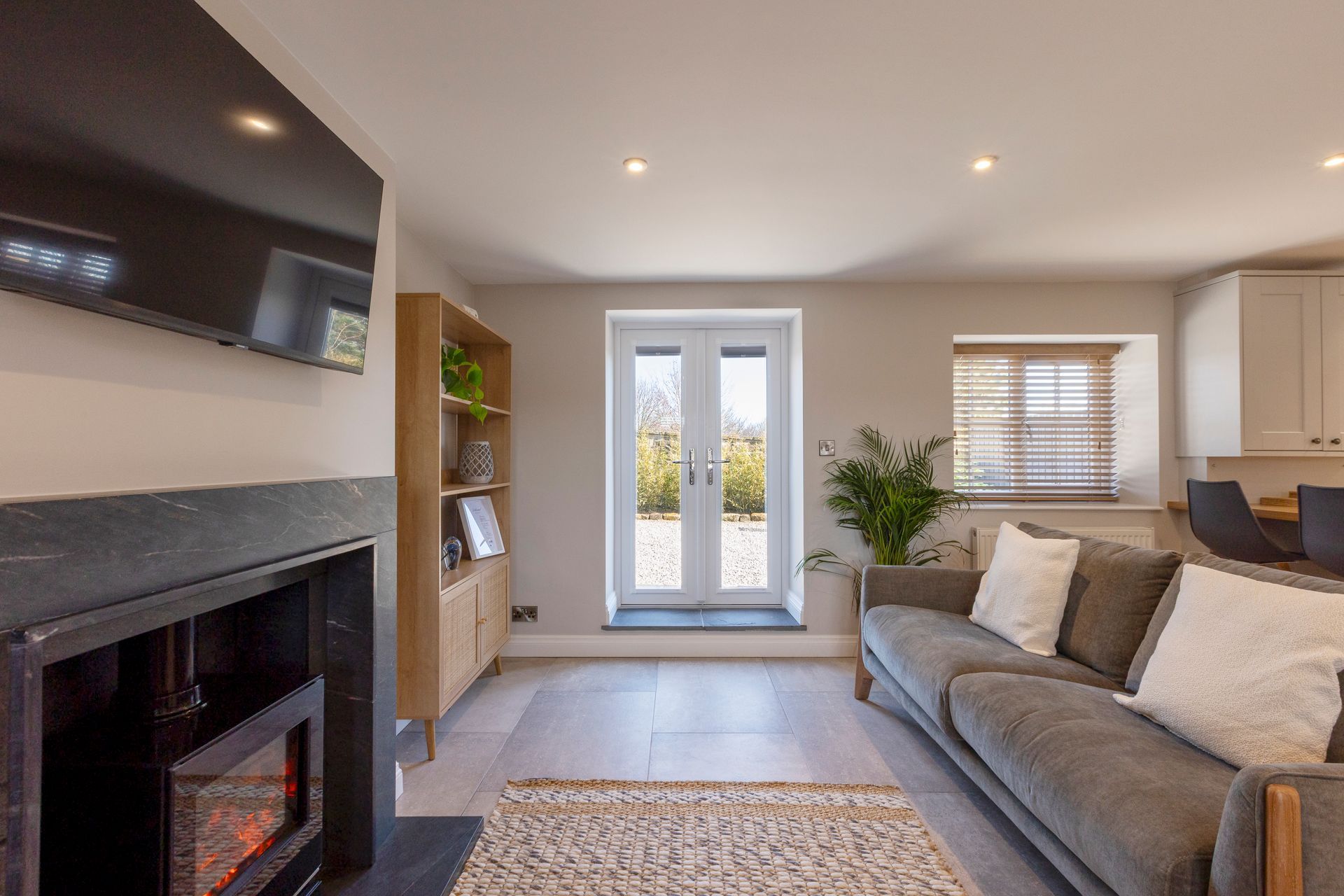 A living room with a couch , fireplace and television.