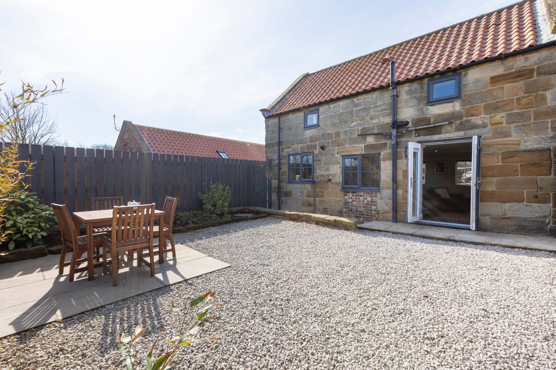 There is a table and chairs in the backyard of a house.