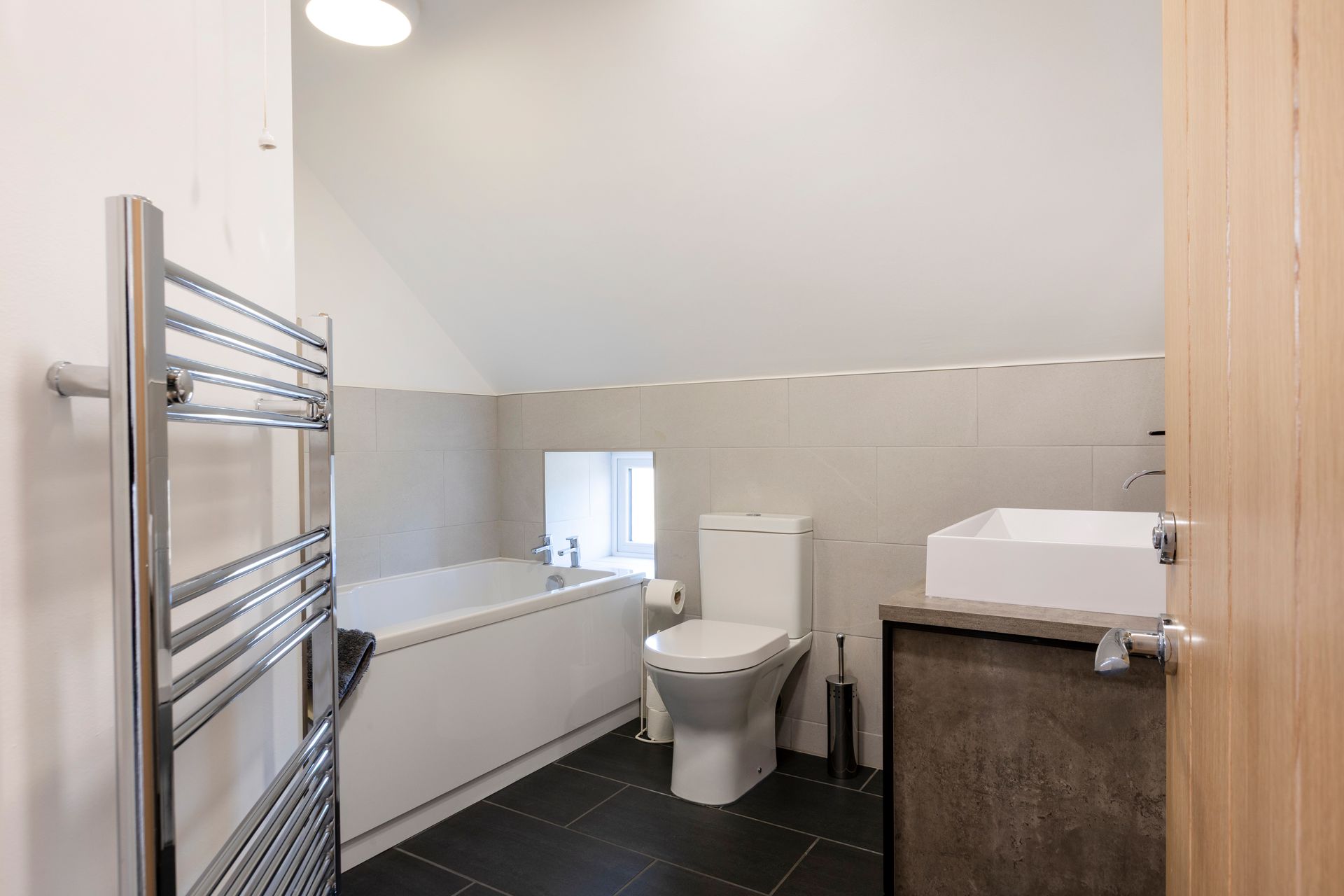 A bathroom with a toilet , sink , bathtub and towel rack.