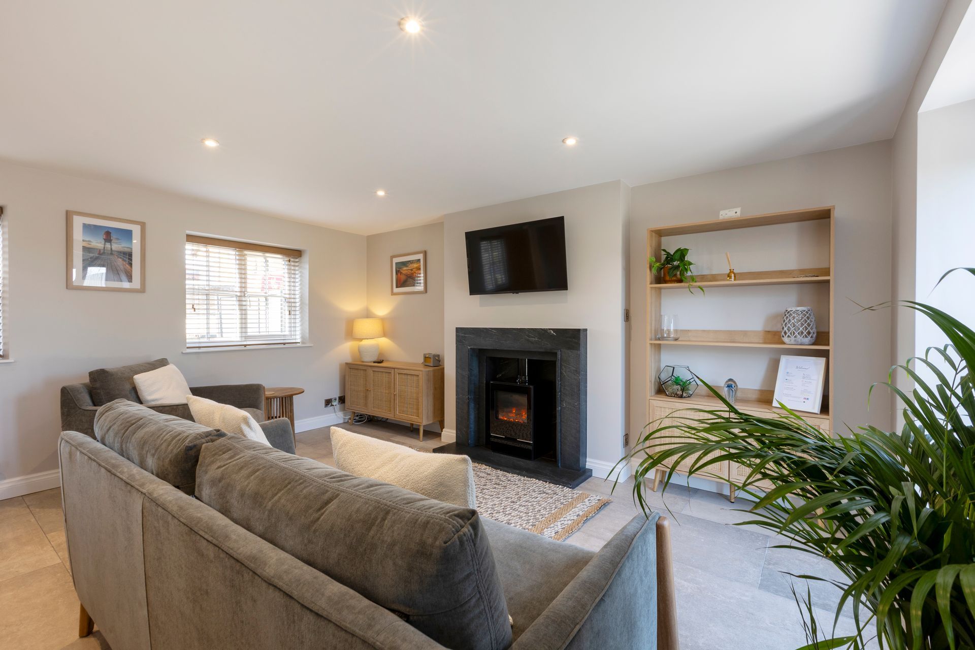 A living room with a couch , chair , fireplace and television.
