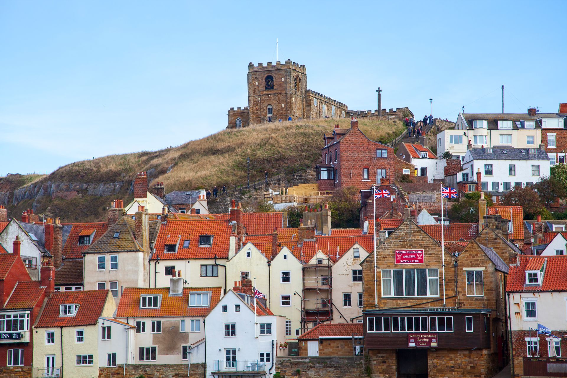 Whitby with a castle on top of a hill in the background.