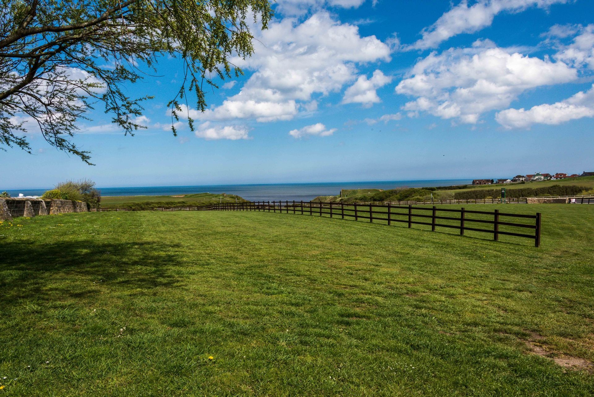 There is a house on the cliff overlooking the ocean.