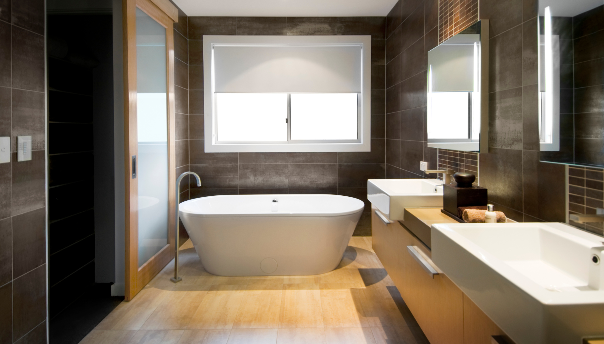 A bathroom with a tub , sink , mirror and window.