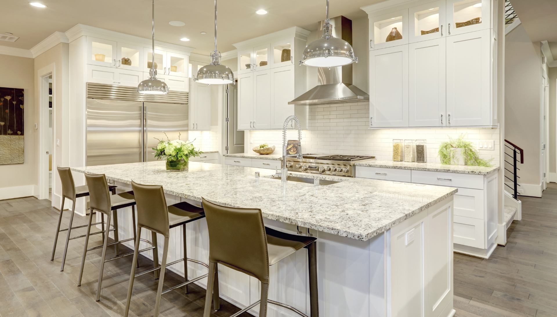 A kitchen with white cabinets , granite counter tops , and stainless steel appliances.